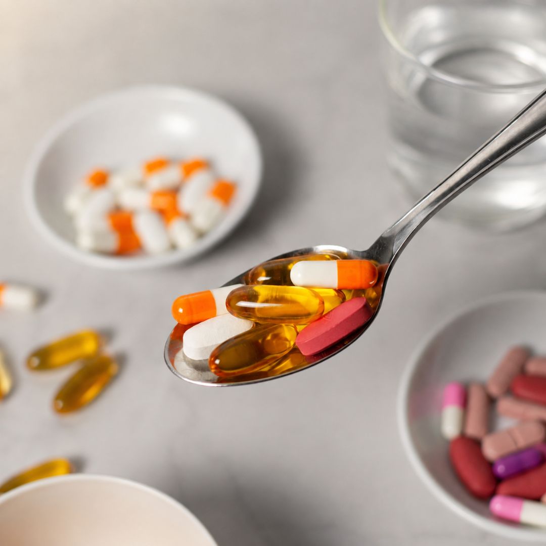 Assorted supplements and vitamins capsules on a spoon